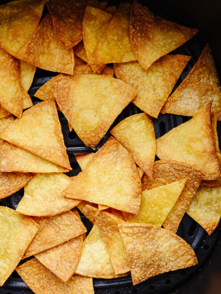 Closeup of chips in air fryer basket.