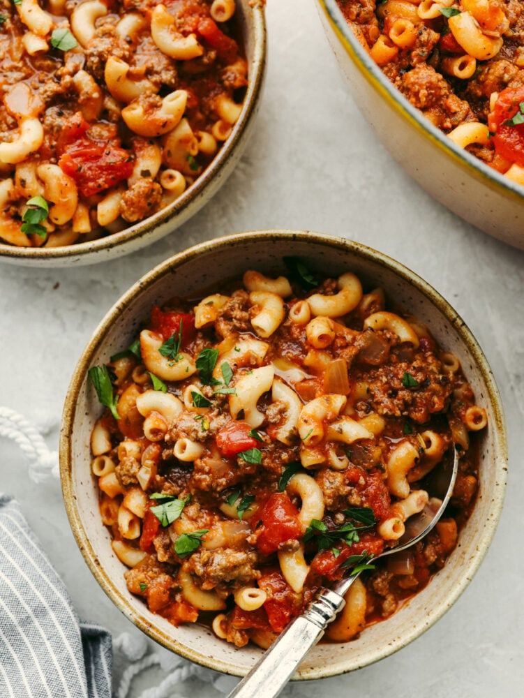 3 bowls of American goulash, each with a spoon. 