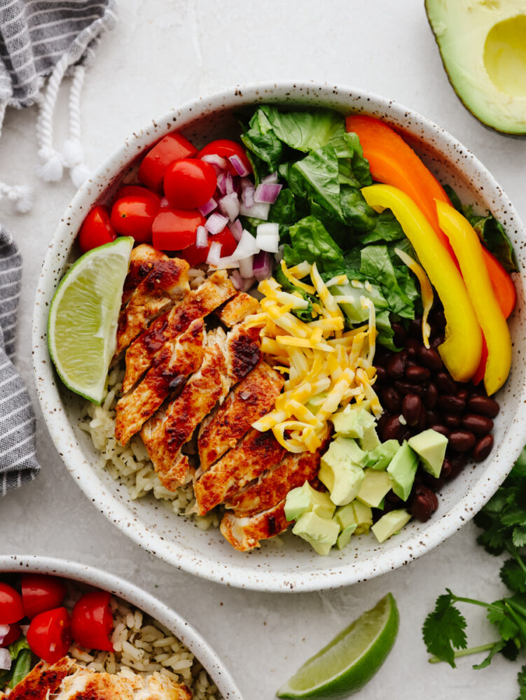 Chicken, vegetables, and beans in a white stoneware bowl.