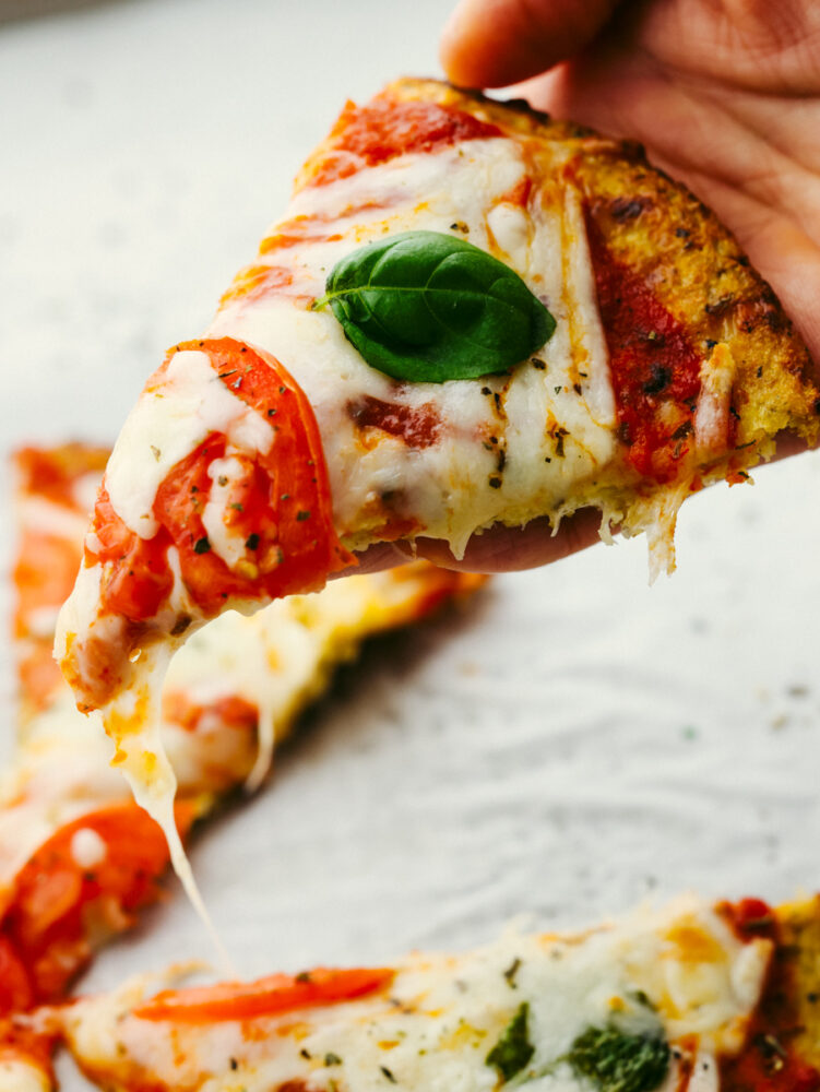 A slice of pizza being held in a hand. 