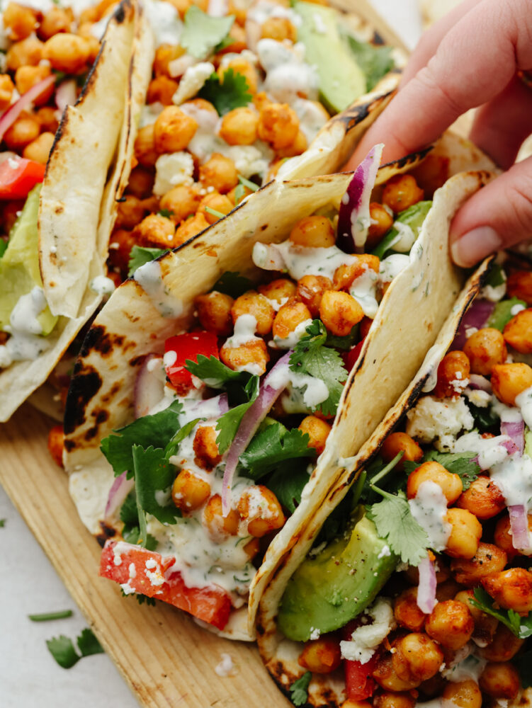 Closeup of a chickpea taco topped with cilantro being held.