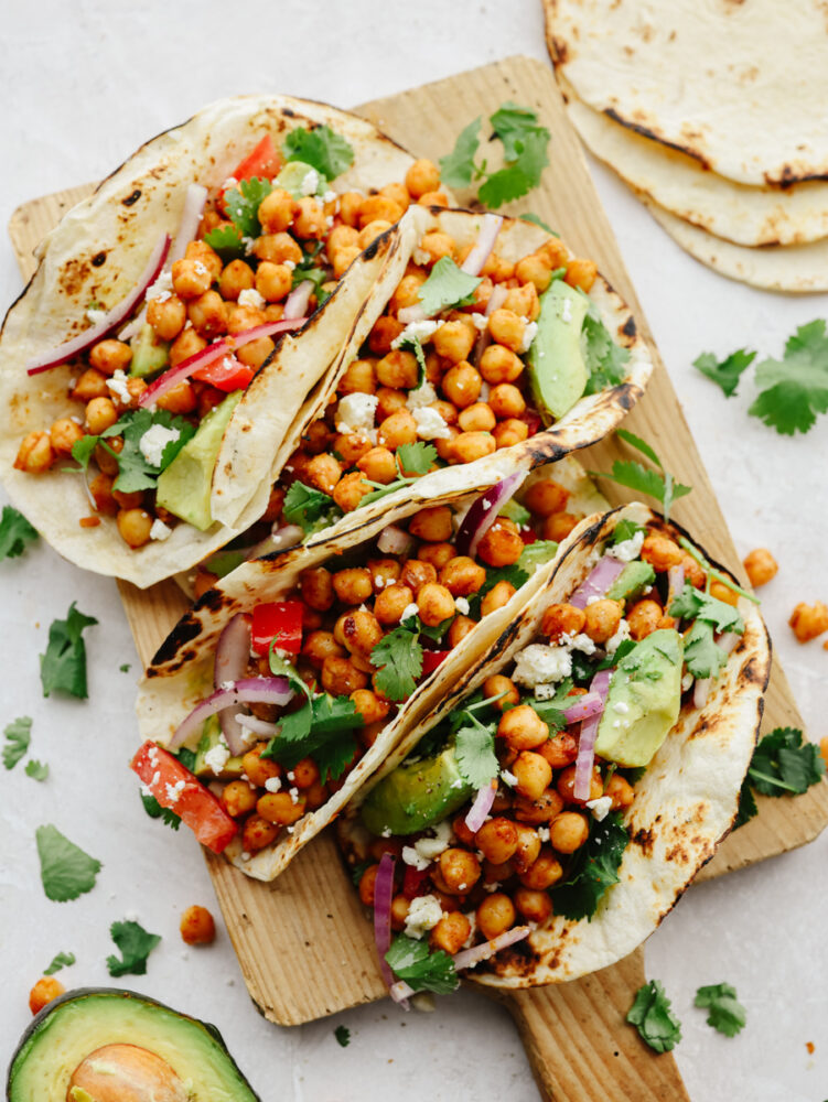 Chickpea tacos on a wooden serving board.