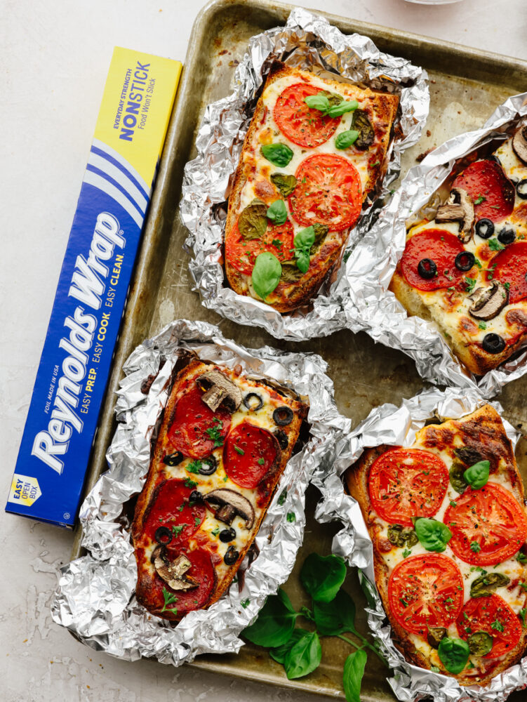 French bread pizzas on a baking sheet after cooking. 