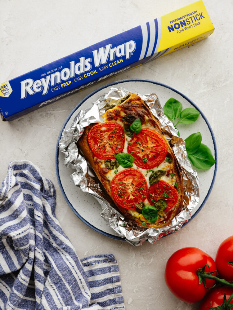 Foil french bread pizza on a plate ready to eat. 