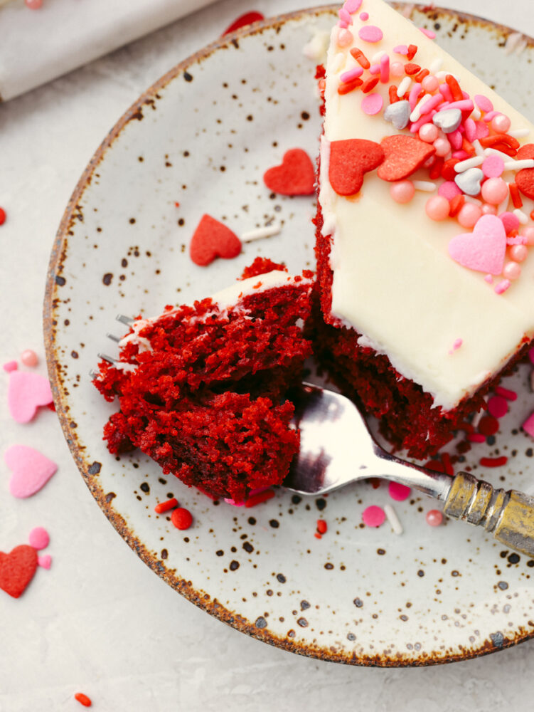 Taking a bite of red velvet cake slice.