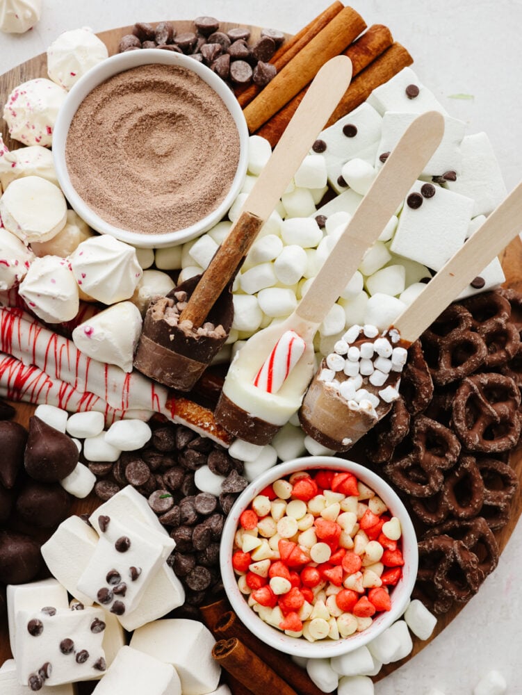 A hot chocolate charcuterie board with marshmallows, hot chocolate mix and chocolate treats. 