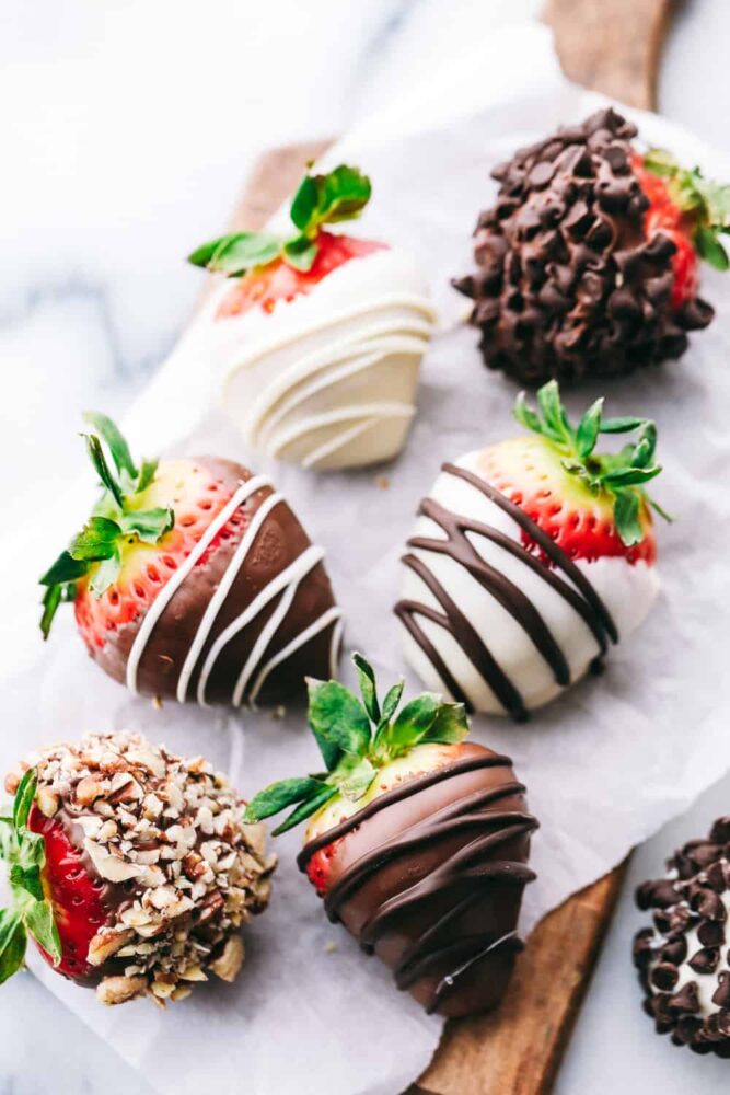 Chocolate covered strawberries on a cutting board. 