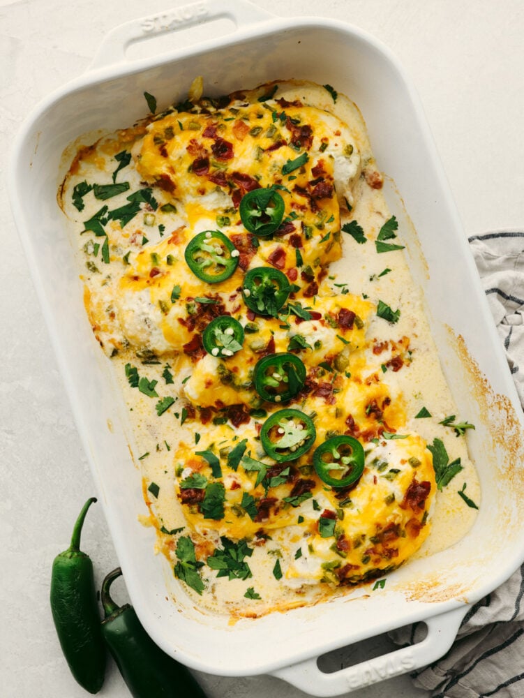 Jalapeno popper chicken in a white casserole dish, garnished with cilantro.