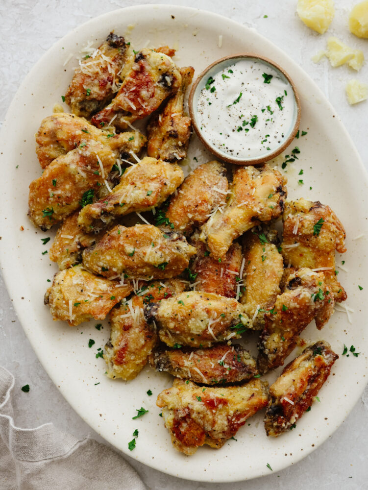 A platter of winger with ranch dipping sauce. 