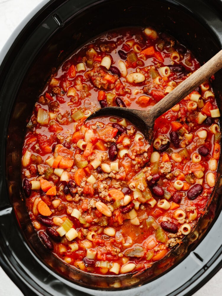 A slow cooker filled with pasta e fagioli all cooked. 