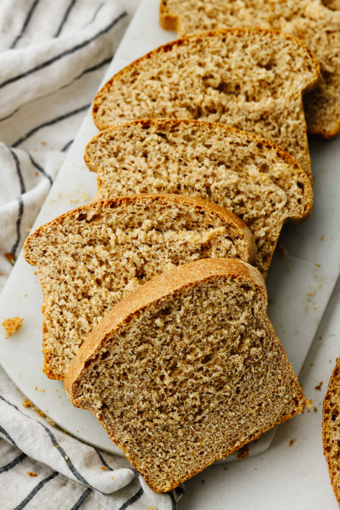 Multiple slices of wheat bread cut and laid on top of each other. 