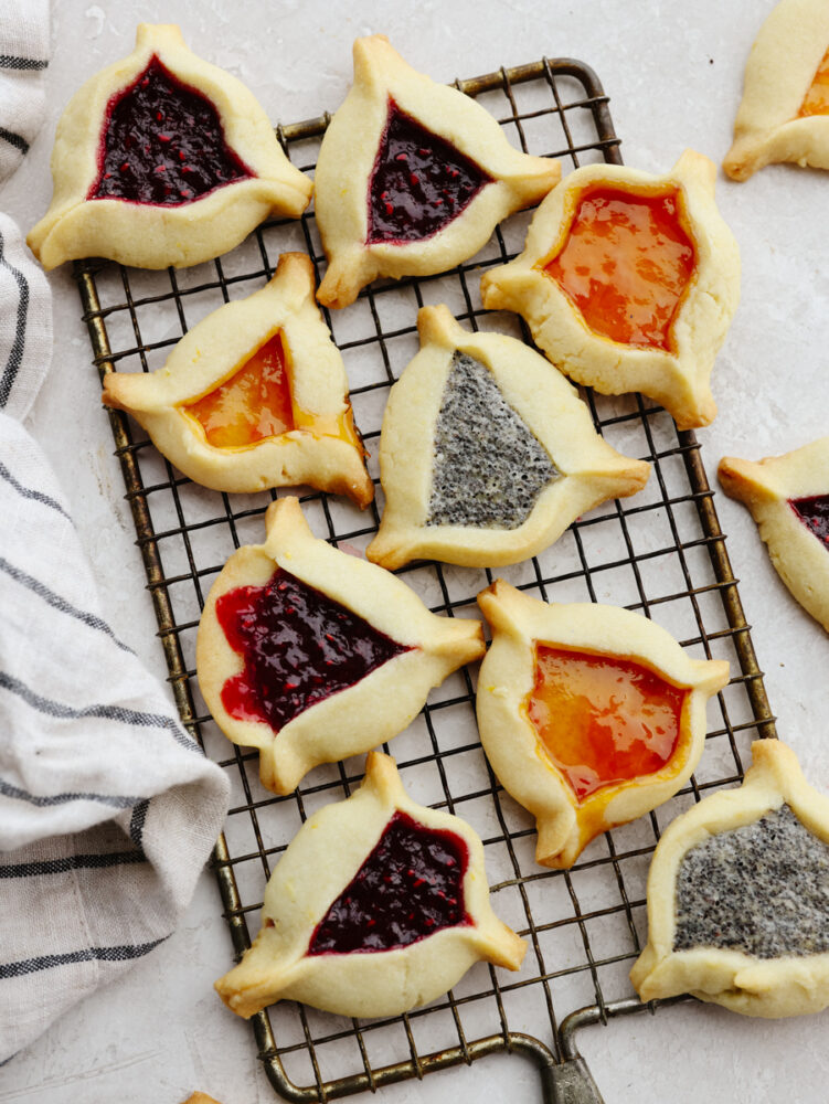 Hamantaschen on a baking rack cooked and ready to eat. 