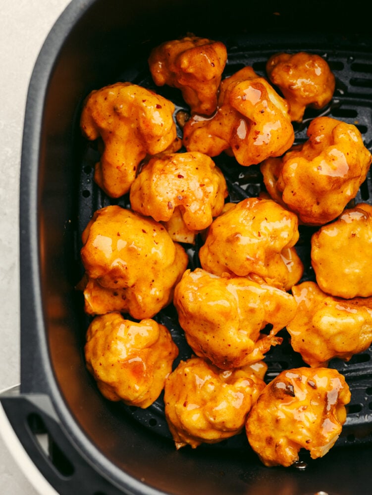 Honey buffalo cauliflower wings in the basket of an air fryer.