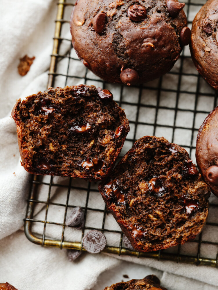 A muffin cut in half on a cooling rack. 