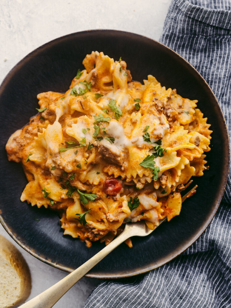 Lasagna on a black stoneware plate.