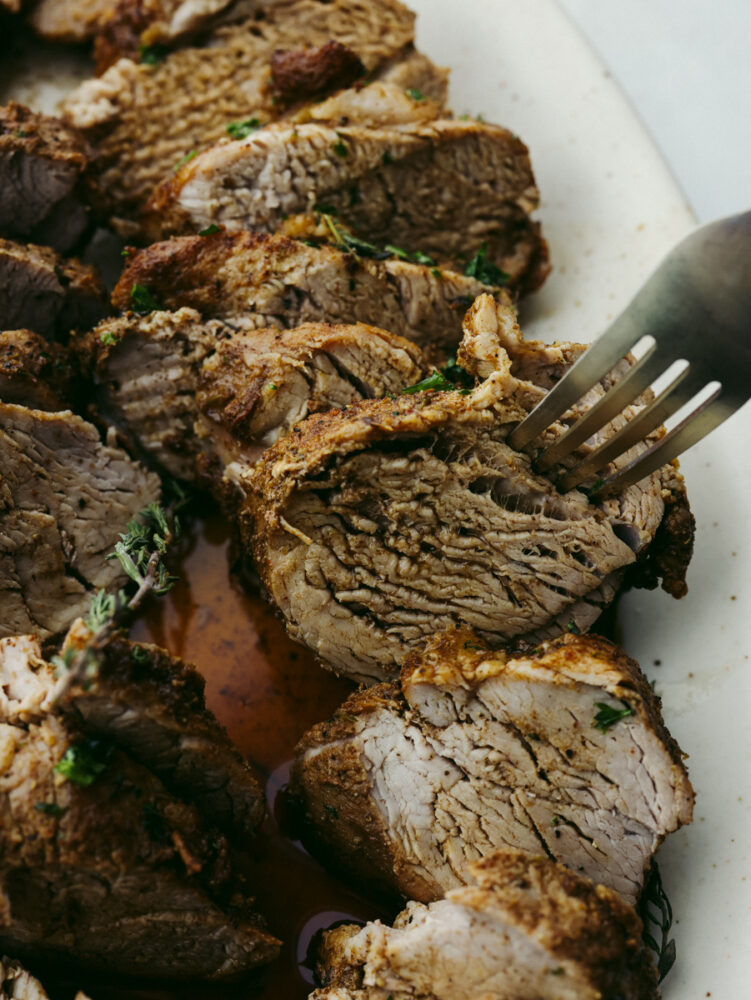 Closeup of taking a slice of tenderloin with a fork.