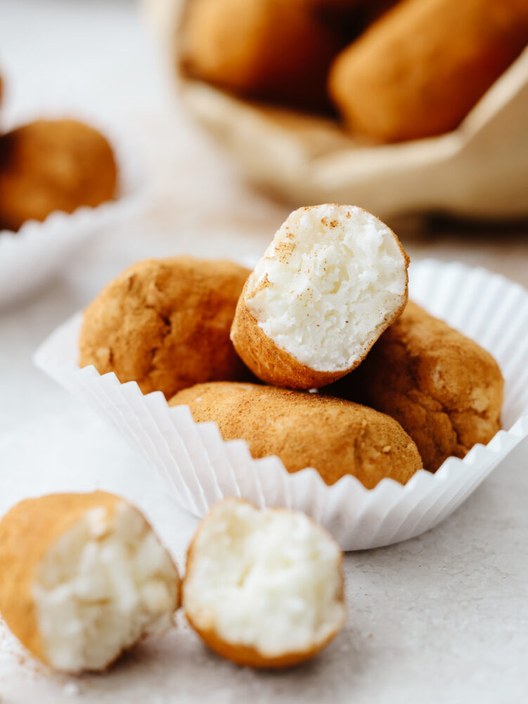 Irish potato candy in a cupcake wrapper. Some broken in half to show the inside of the candy. 