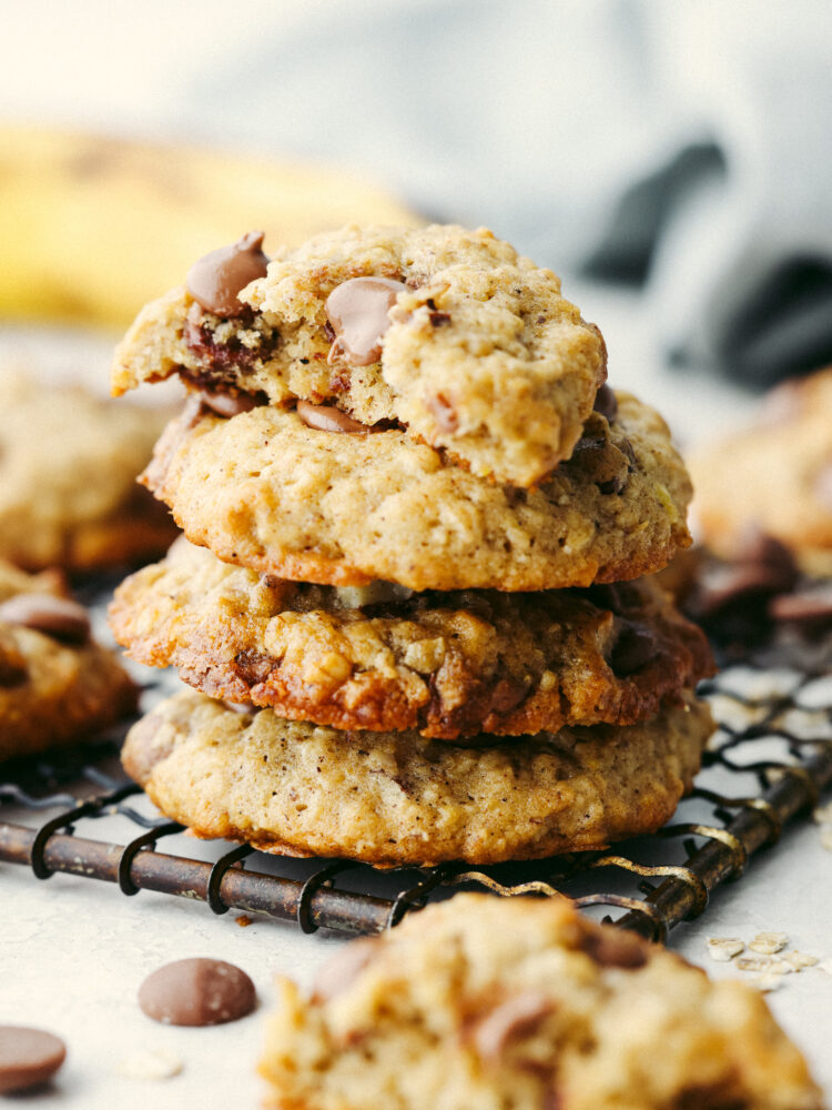 A stack of 4 cookies, one with a bite taken out of it.