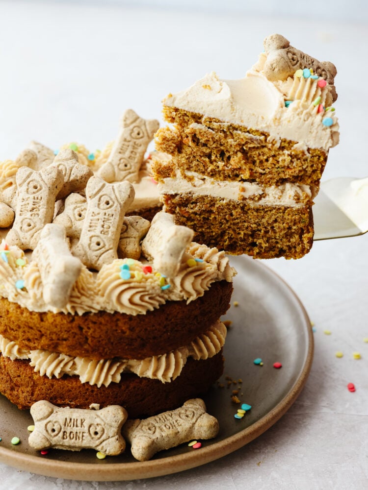 Taking a slice of dog birthday cake with an icing spatula.