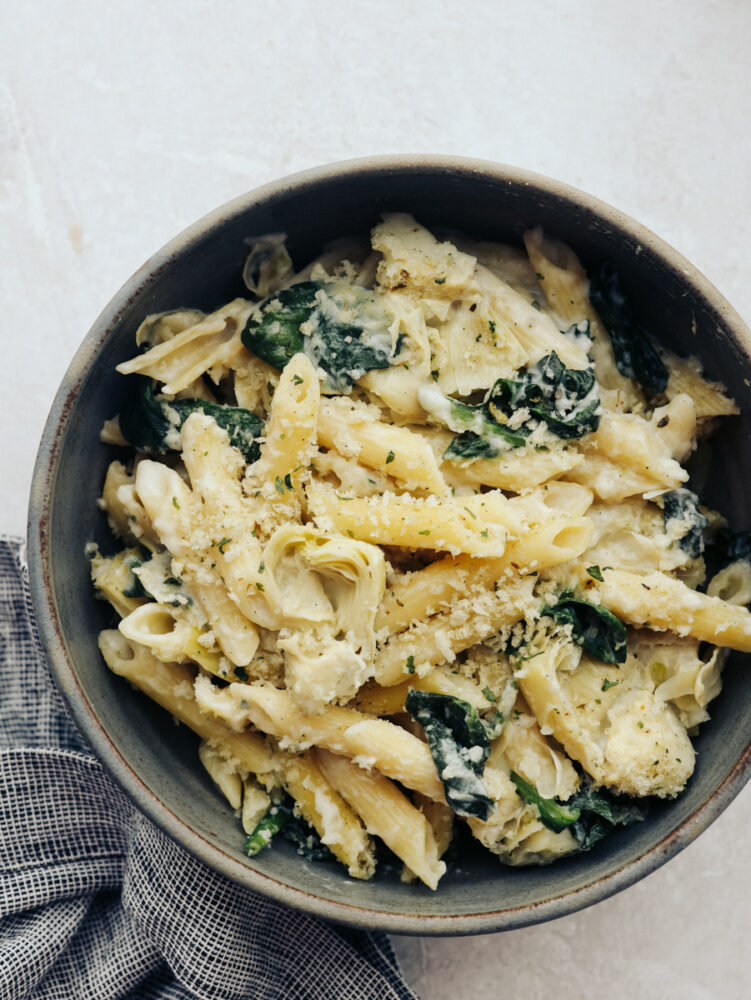 A bowl of spinach artichoke pasta. 