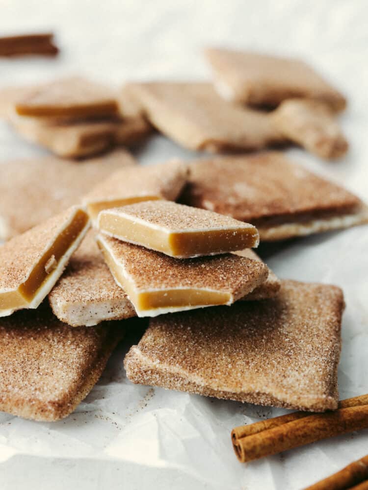 A zoomed in shot of toffee that is broken into pieces on parchment paper. 