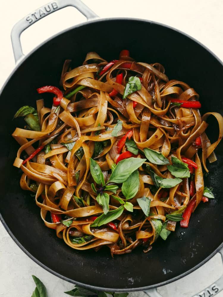 A pan filled with cooked drunken noodles. 