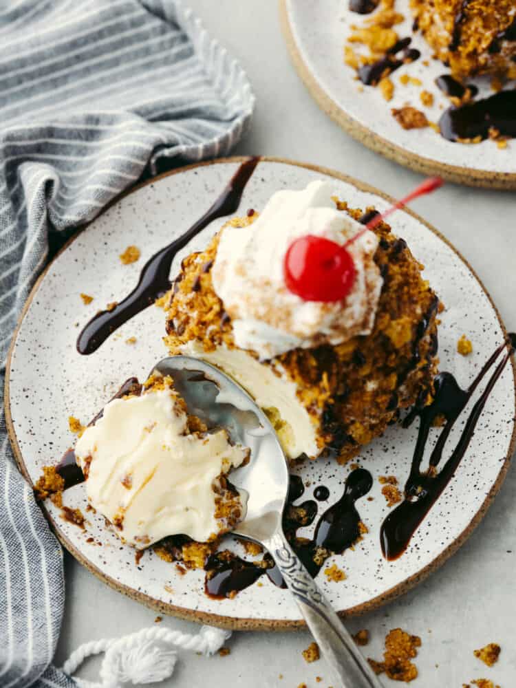 Top-down view of a bite being taken out of fried ice cream with a silver spoon.