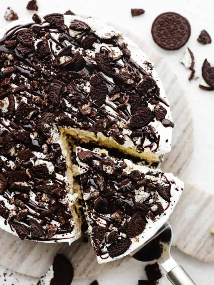 The top view of an ice cream cake with a. slice being pulled out with a cake server. 