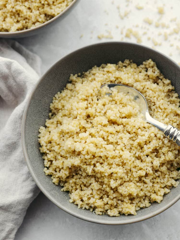 A bowl of quinoa with a silver spoon in the bowl with it. 