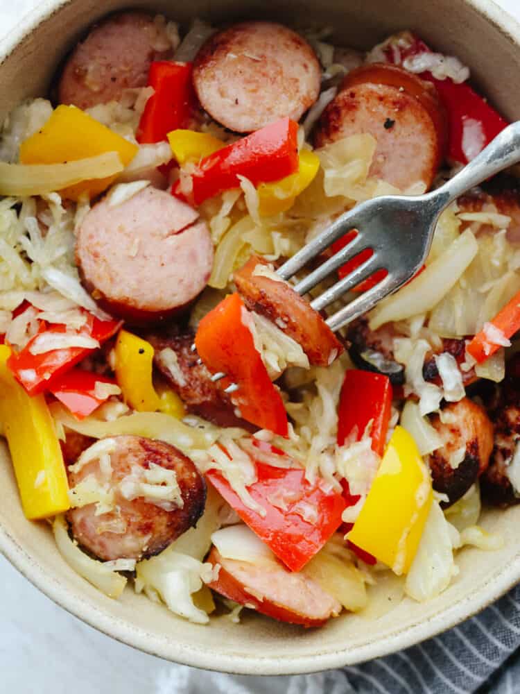 Kielbasa and Sauerkraut in a bowl with a fork. 