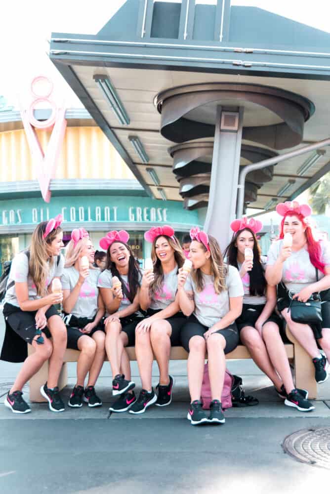 The Recipe Critic team eating ice cream on a bench in Disneyland.