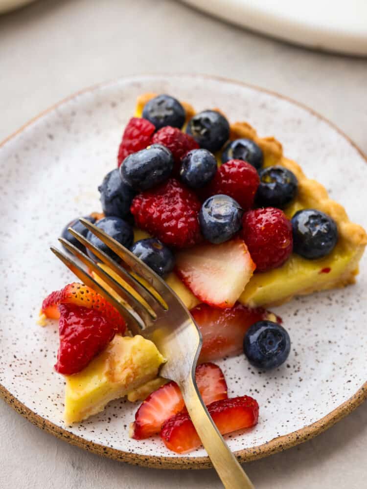 Closeup of a piece of tart being cut by a fork.