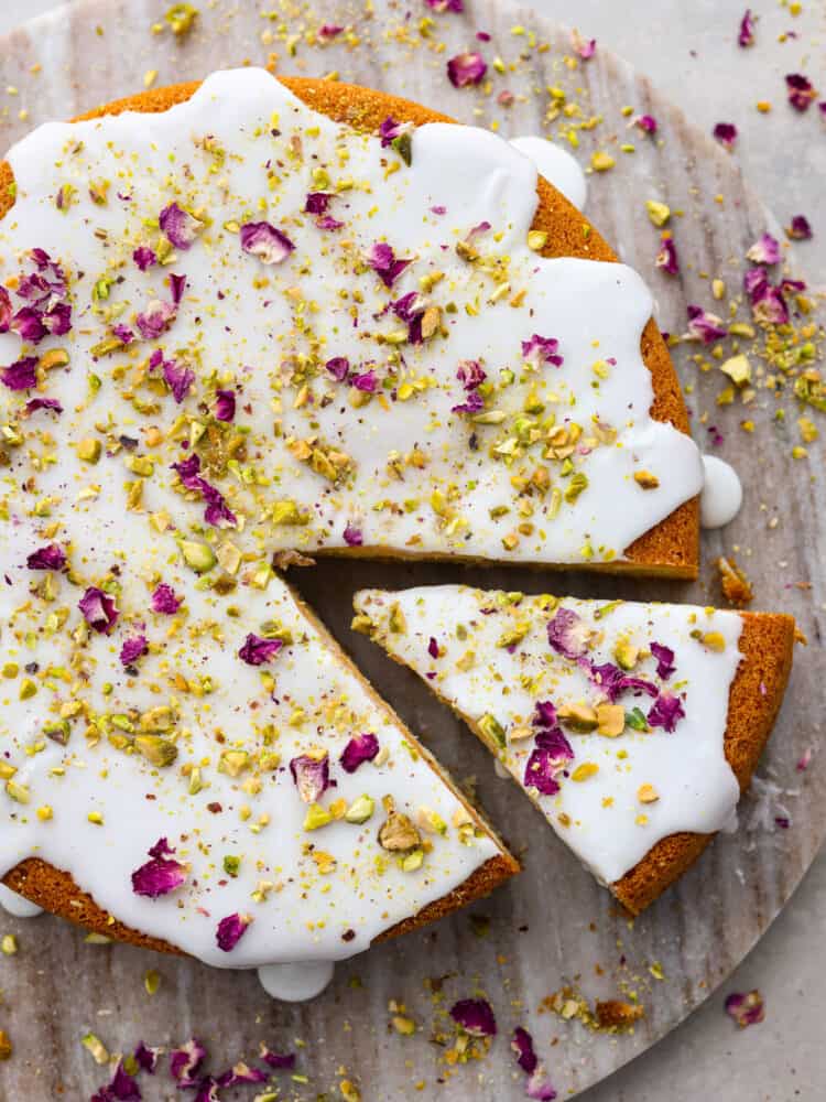 The top view of a Persian love cake with a slice slightly removed from the center. 