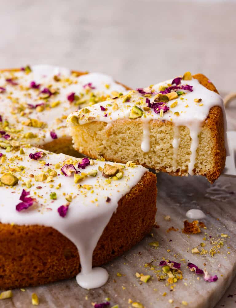 A slice of Persian love cake being lifted out with a cake server. 