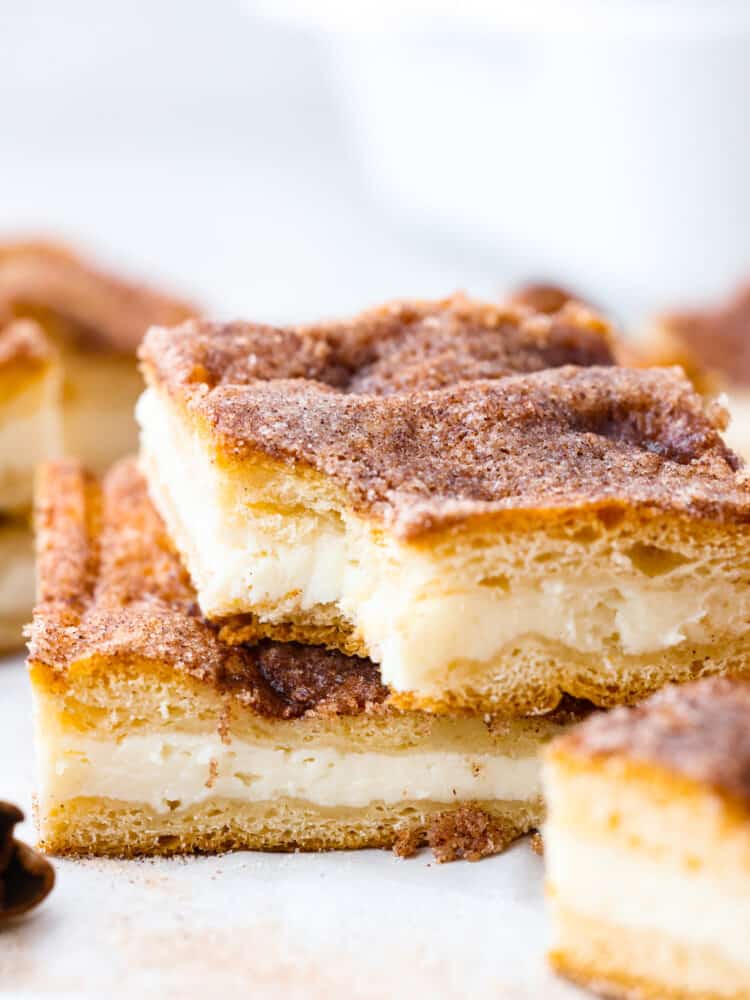 2 sopapilla bars stacked on one another. The top one has a bite taken out of it. 