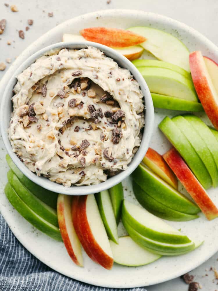 Dip in a bowl on a platter filled with apple slices. 