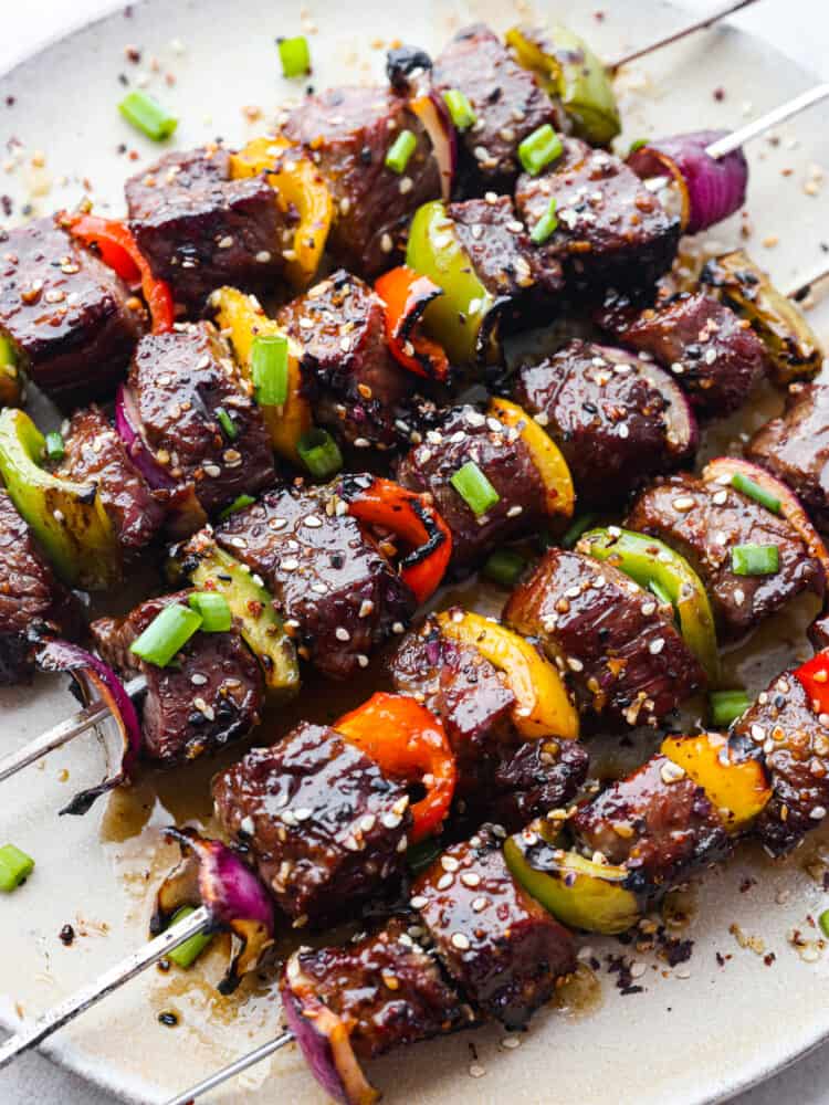 Asian garlic steak skewers on a platter, ready to eat. 