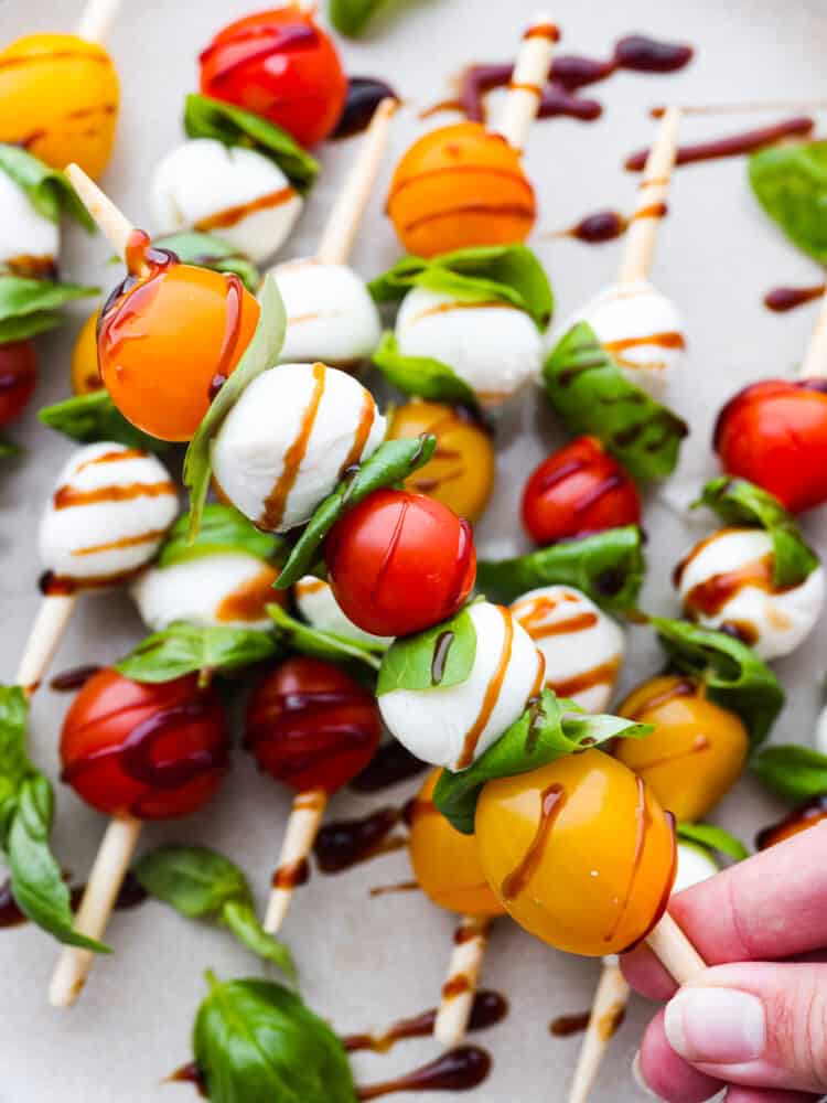 Closeup of a Caprese skewer being held.