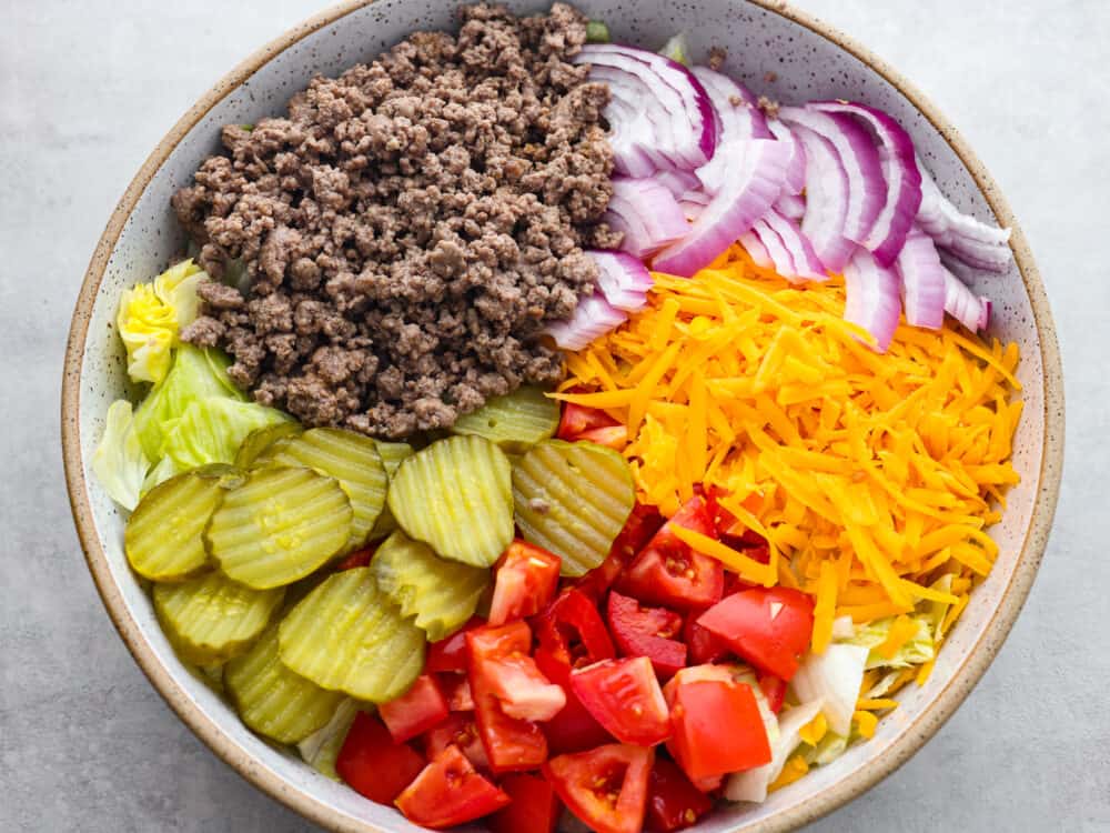 A top view of the salad ingredients separately sectioned in a large bowl.