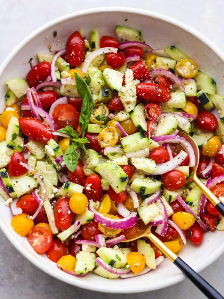 The top view of a bowl of chilled cucumber tomatoe salad. 