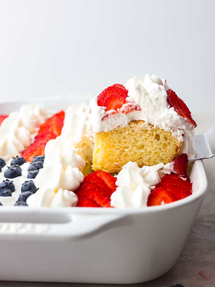 The side view of a slice of cake being served out with a silver cake server. 