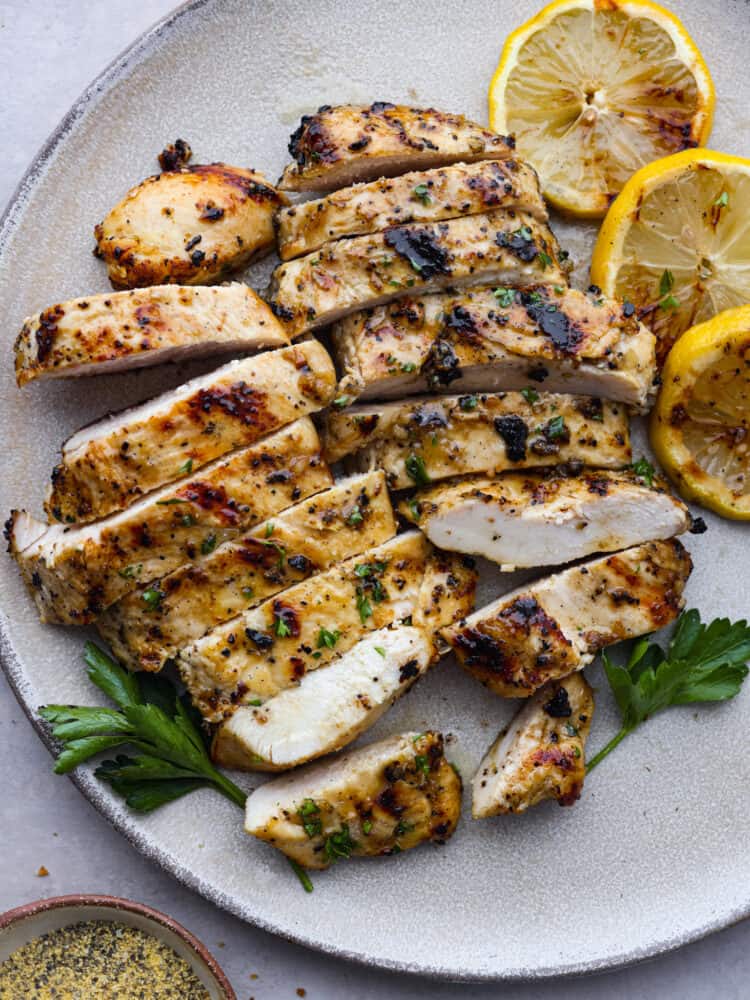 Grilled chicken on a plate, sliced and ready to eat. 