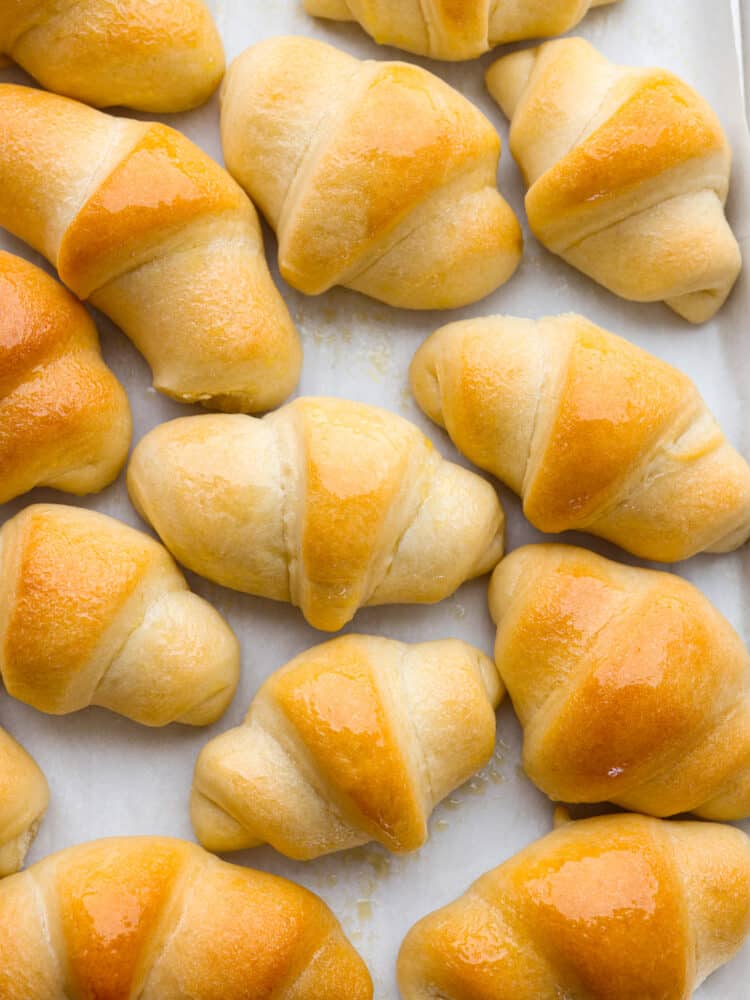 Homemade crescent rolls cooked on a baking sheet with parchment paper. 