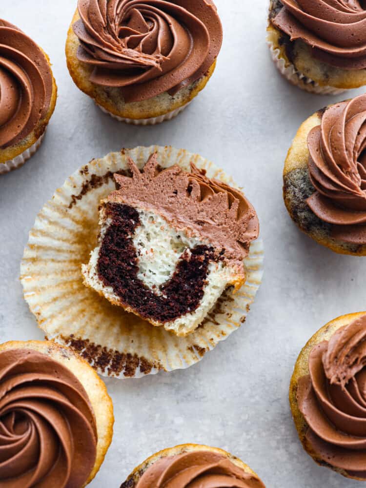 A marble cupcake sliced in half and taken out of the wrapper so that you can see the inside. 