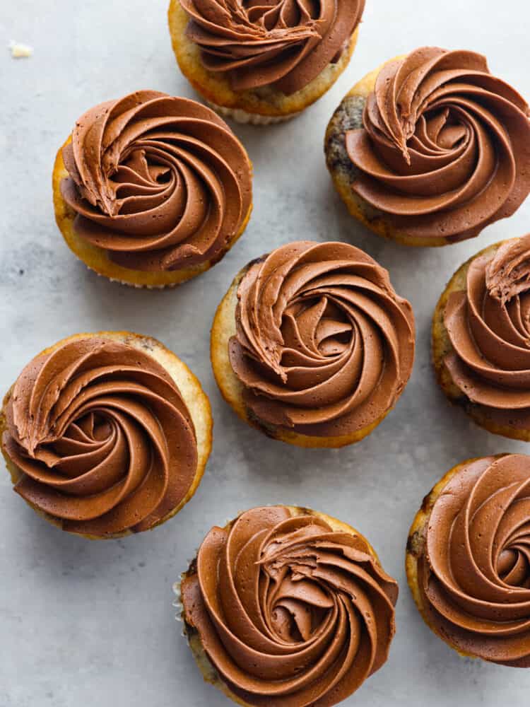 The top view of cupcakes that are piped with chocolate buttercream frosting. 