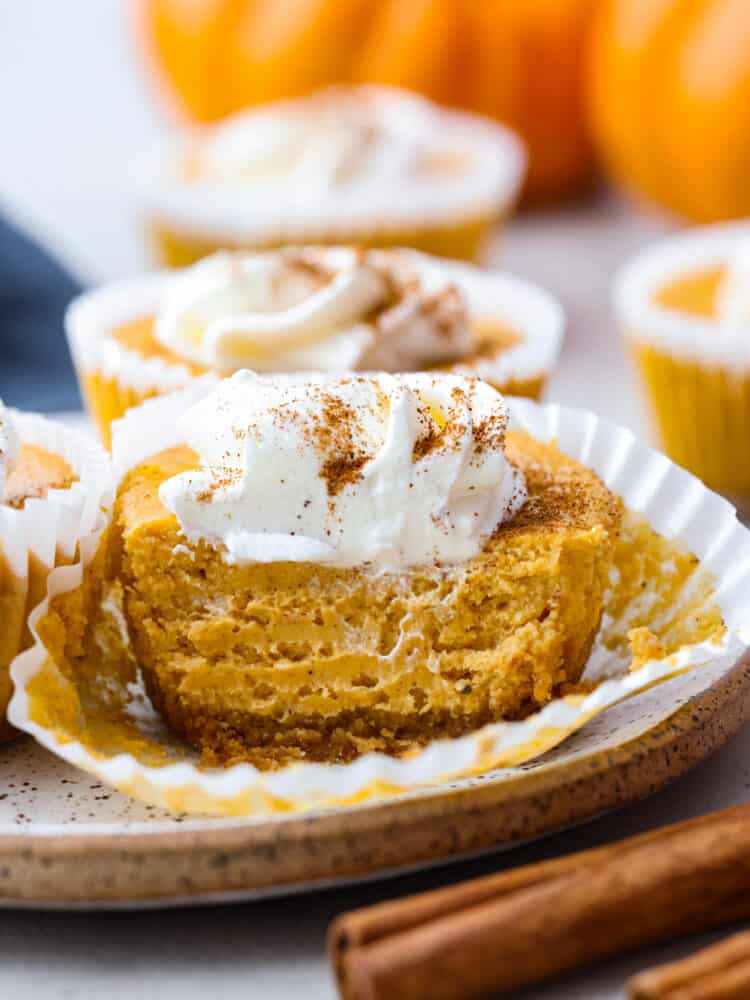 Closeup of a mini pumpkin cheesecake, cut so the inside can be seen.