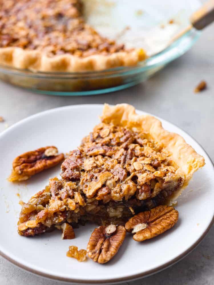 A slice of oatmeal pecan pie on a white plate. 