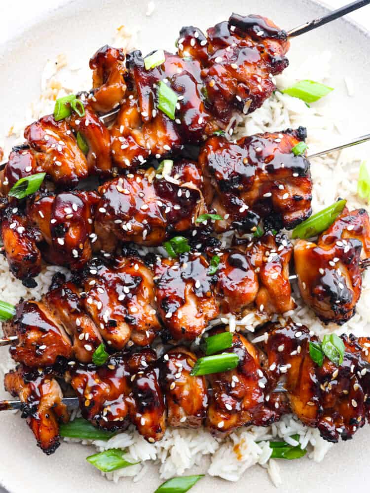 Closeup of yakitori skewers on a bed of white rice.