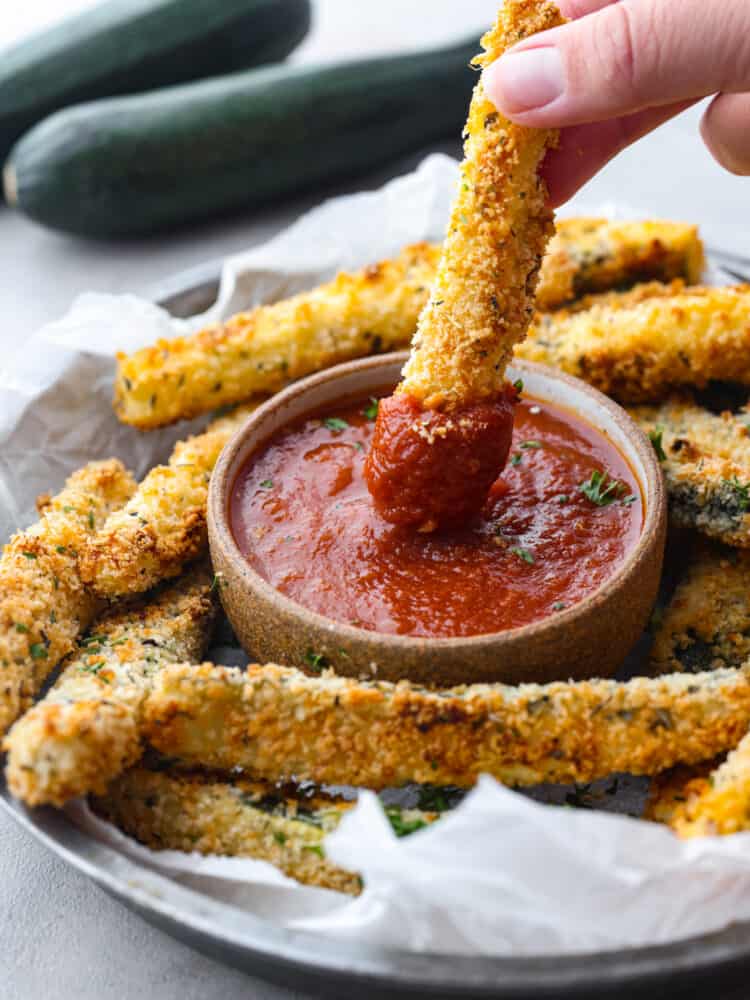 Dipping a fry in marinara sauce.