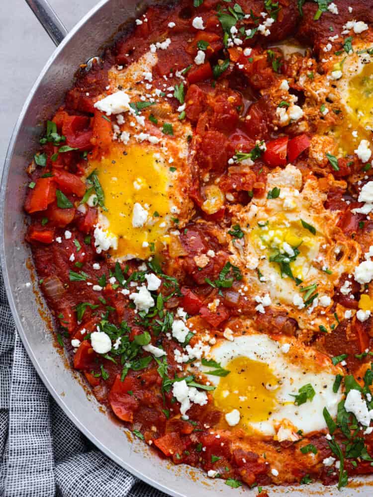 Closeup of shakshuka in a metal skillet.